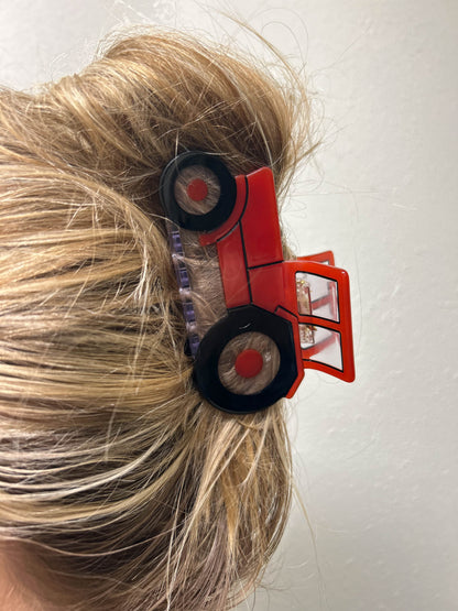 Photo featuring a woman's hair embellished with a red Tractor Hair Clip