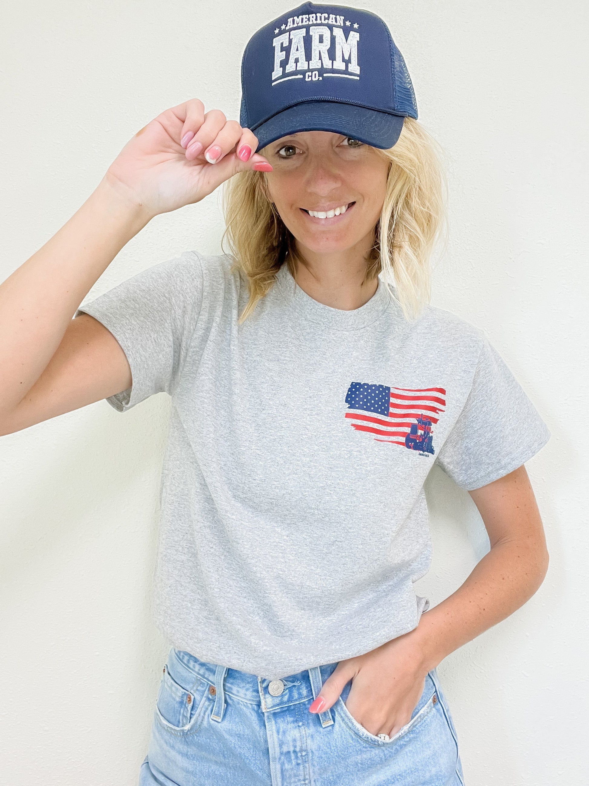 Woman wearing a american farmer tee with blue american farm com hat