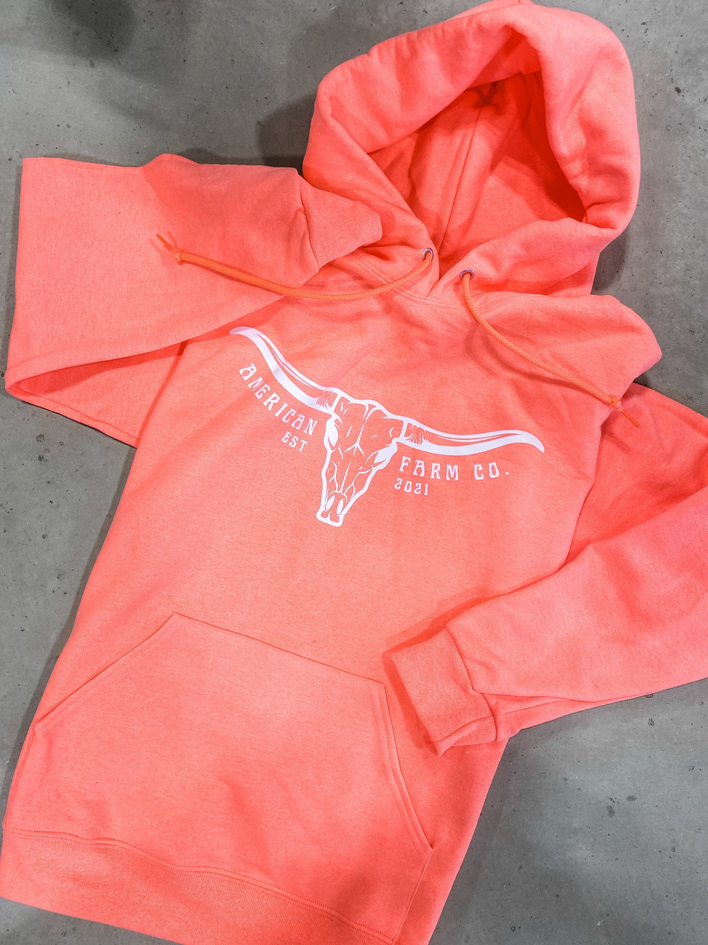 Neon orange skull hoodie shown on brown background