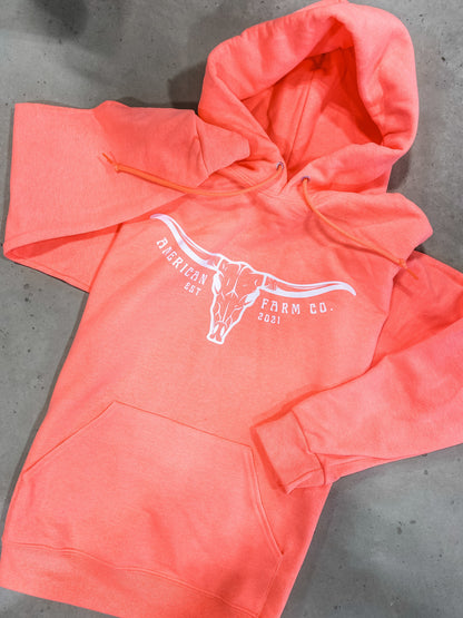 Neon orange skull hoodie shown on brown background