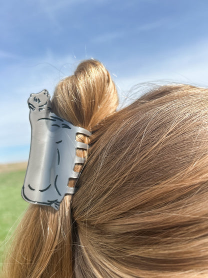 A woman in a field with her hair styled using a Metallic Beef Cow Claw Clip